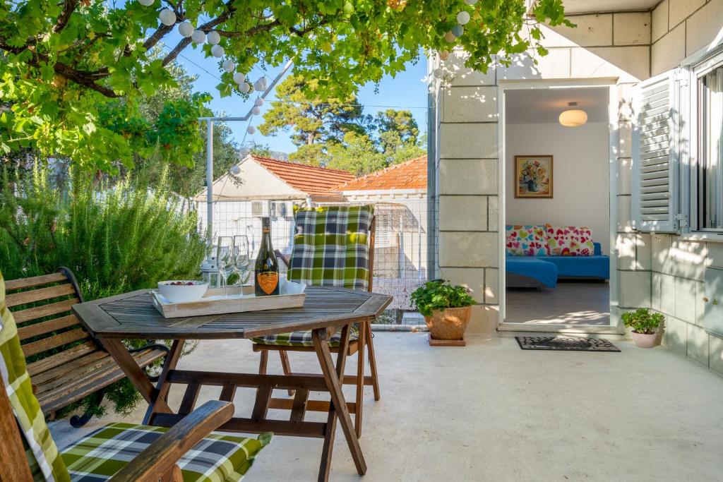 a patio with a wooden table and chairs at Teranino Apartment in Dubrovnik
