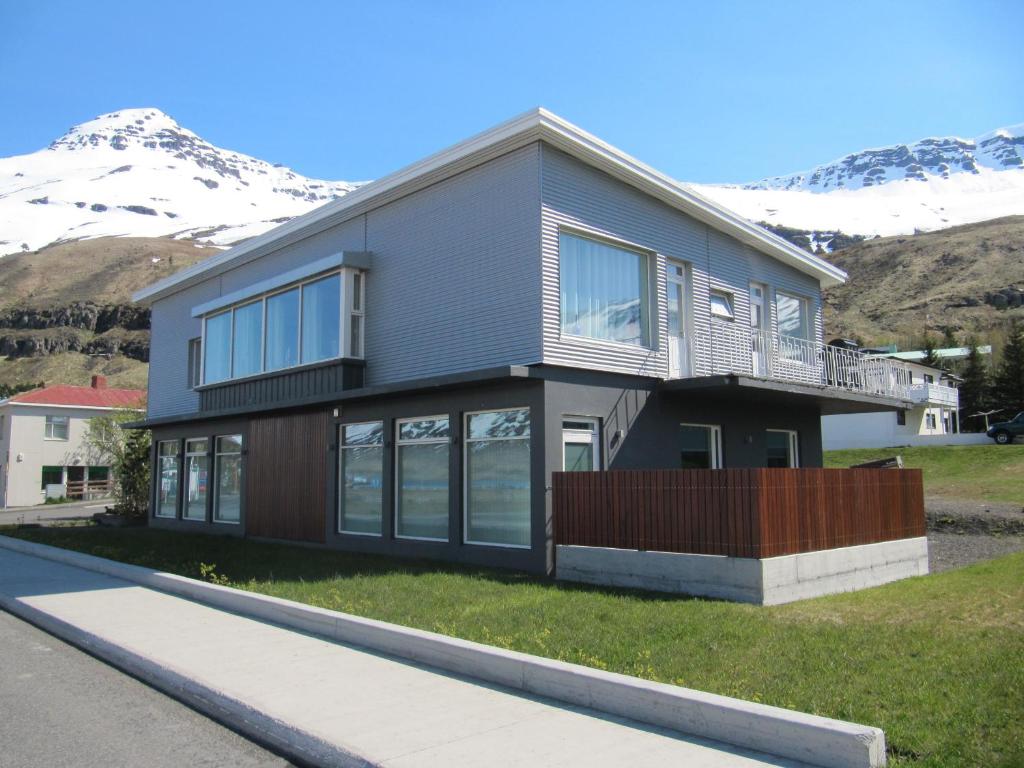 ein großes Haus mit Bergen im Hintergrund in der Unterkunft Seydisfjördur Apartment in Seyðisfjörður