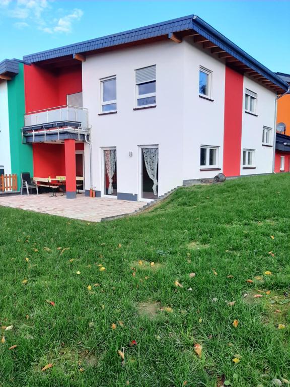 ein Haus mit einem grünen Rasen davor in der Unterkunft Ferienhaus 1 - 55483 Unzenberg in Göbenhausen