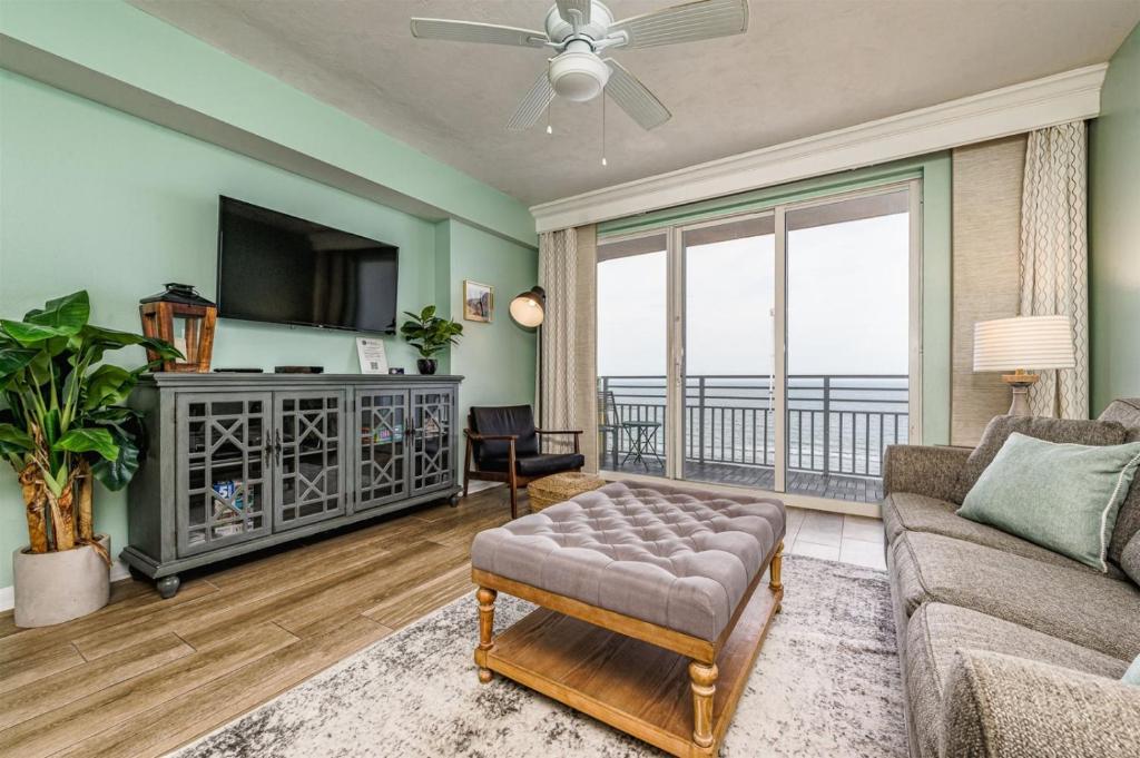 a living room with a couch and a balcony at Unit 1207 Ocean Walk - 1 Bedroom Ocean Front in Daytona Beach