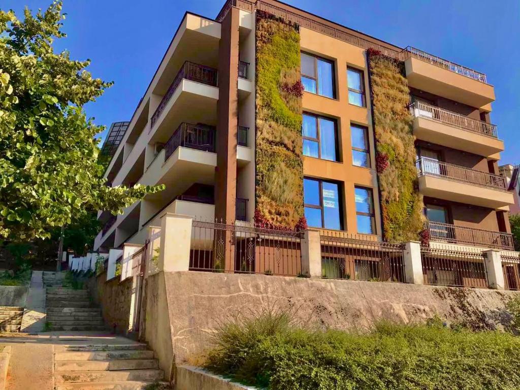 un immeuble d'appartements avec des plantes sur son côté dans l'établissement Comfort Luxury Apartments, à Vratsa
