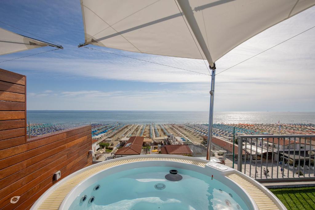 a hot tub in a building with a view of a beach at Beachfront Penthouse with private parking in Camaiore