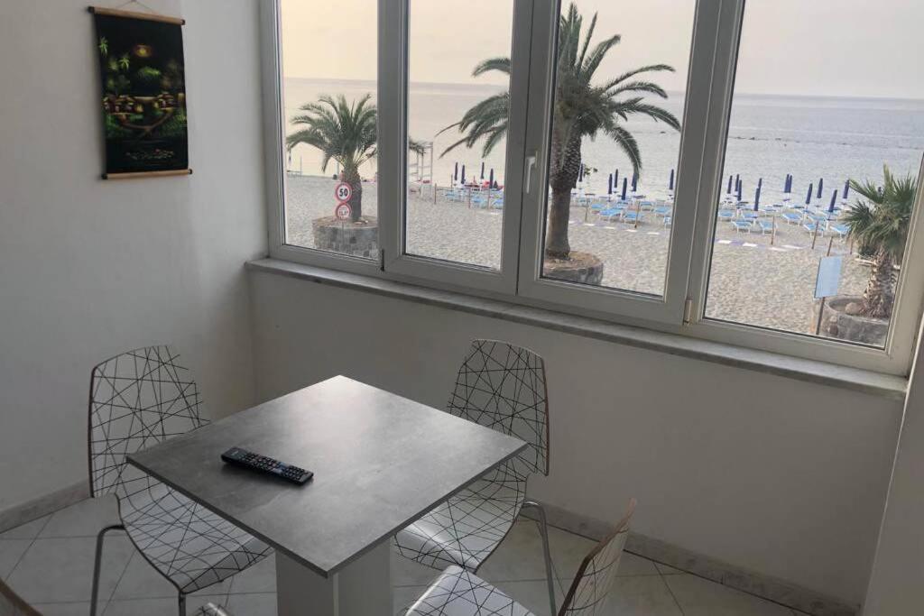 una mesa con dos sillas y un mando a distancia en ella en Casa Rita in Piazza Marina en Isquia