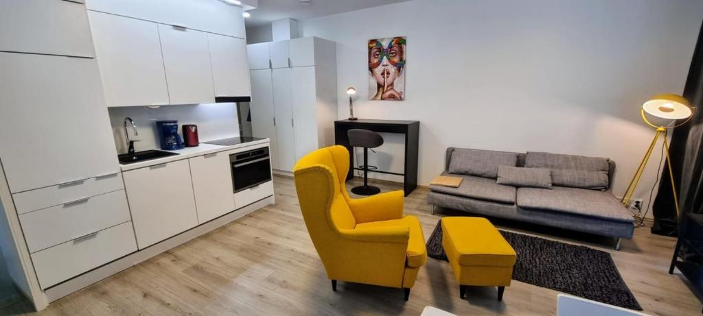 a living room with a yellow chair and a couch at Nordica central apartment in Rovaniemi