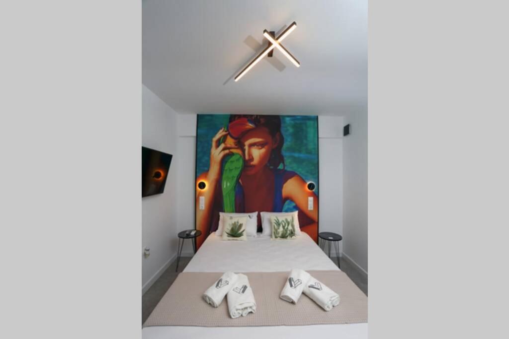 ein Schlafzimmer mit 2 Betten und einem Gemälde an der Wand in der Unterkunft Valory #8 Aesthetic Stay in Thessaloniki