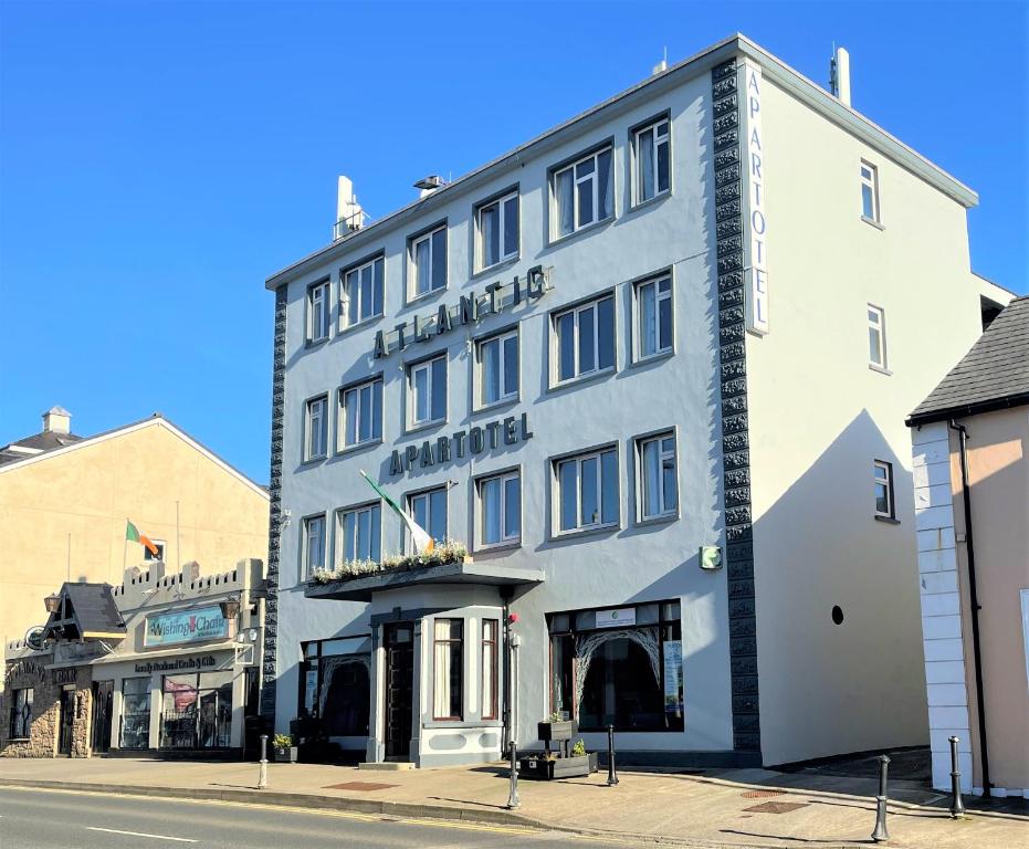 a large white building on the corner of a street at Atlantic Apartotel in Bundoran