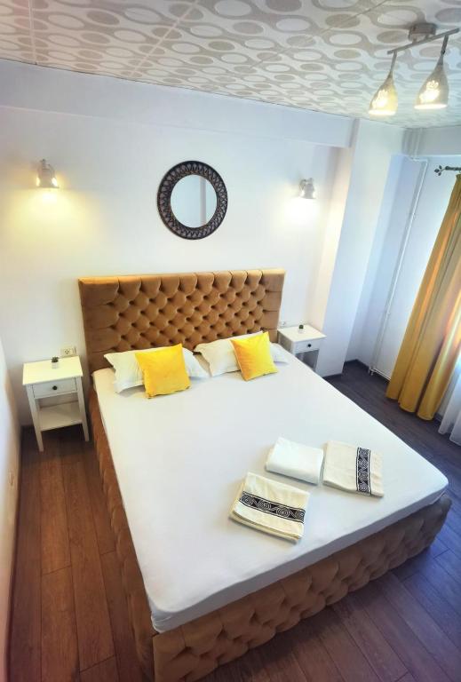 a bedroom with a large white bed with yellow pillows at Casa Laura in Mangalia
