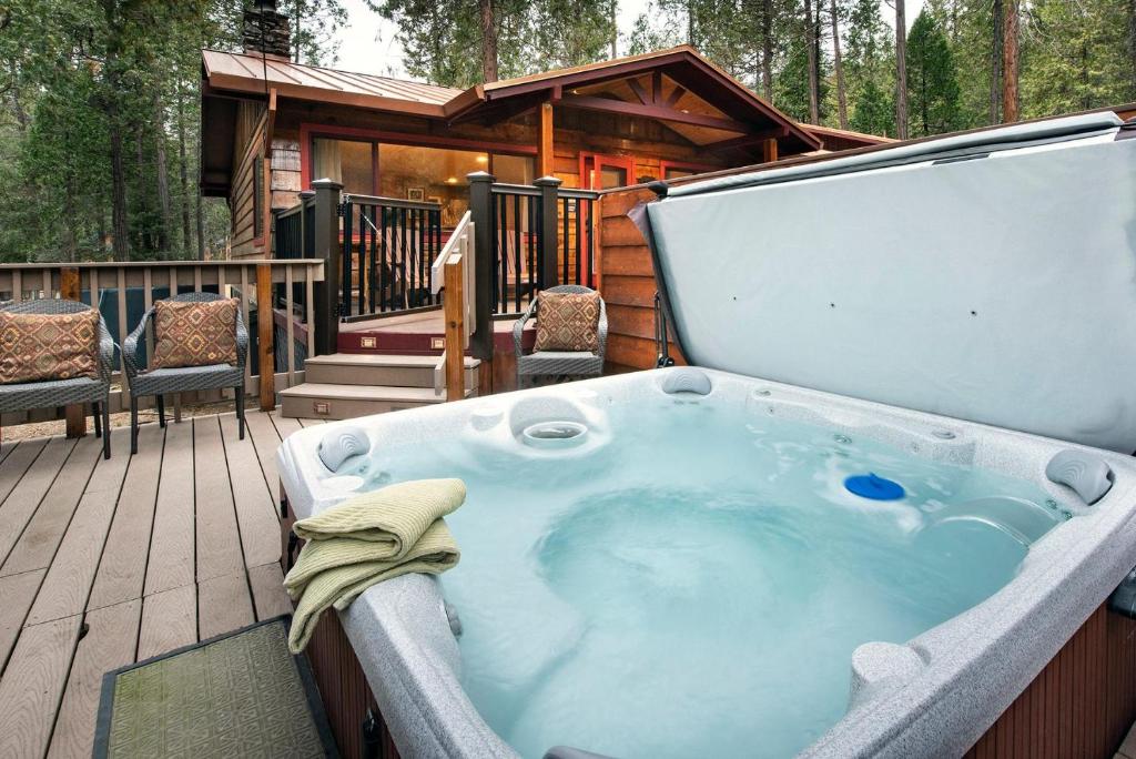 a jacuzzi tub on a deck with a cabin at Buss Stop in Wawona