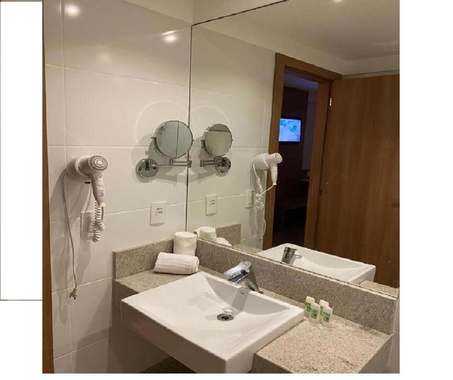 a bathroom with a sink and a mirror at Condominio Vista azul Flat-Hotel in Pedra Azul