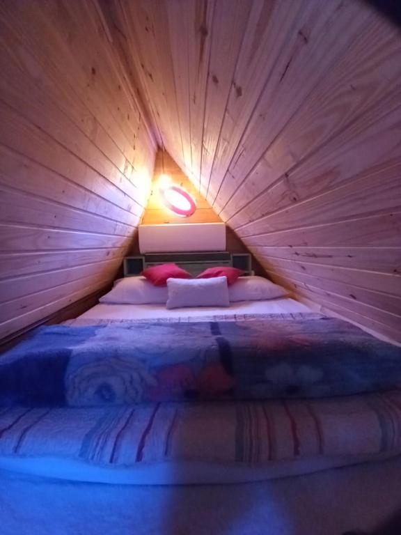 a bedroom with a bed in a wooden tent at Mini House Park in Campo Alegre
