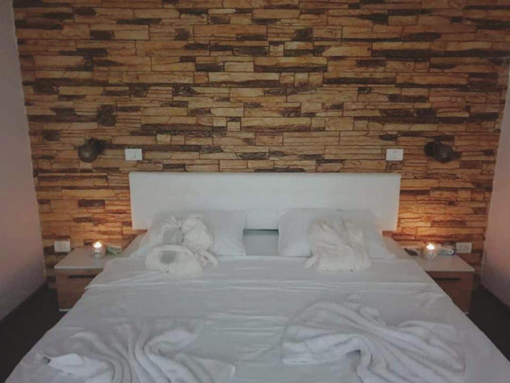 a bed with towels on it with a brick wall at Insomnia Studio in Drobeta-Turnu Severin