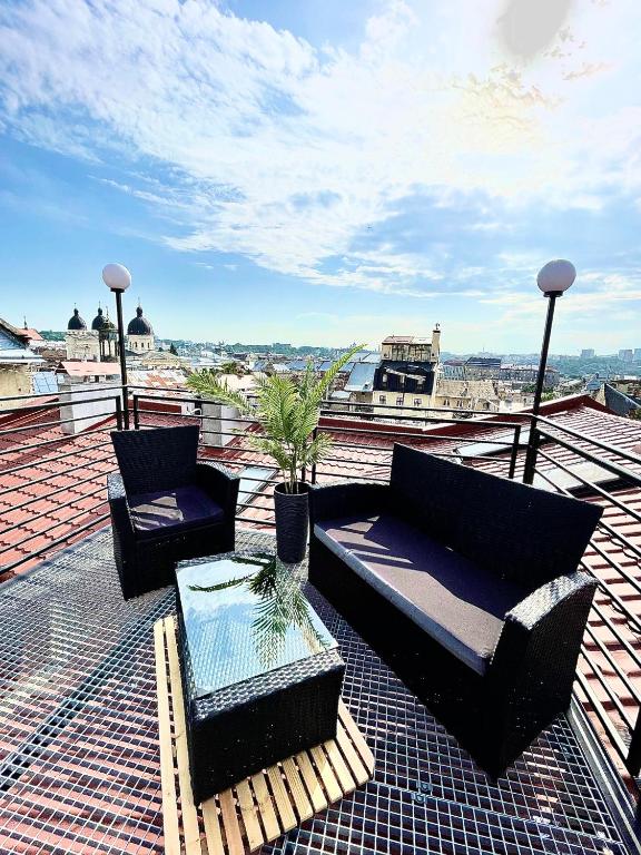 a patio with two couches and a table on a roof at Gamla Stan in Lviv