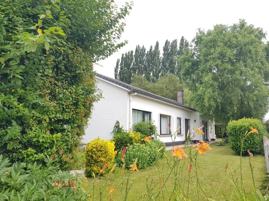 une maison blanche avec un jardin en face dans l'établissement Mary's Poppies - Bed & Breakfast, à Blandain