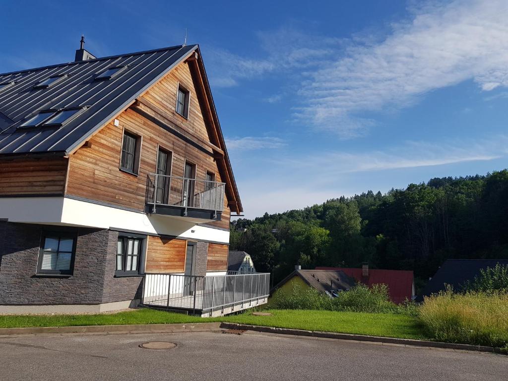 uma casa de madeira com uma varanda ao lado em Apartmán Alfa 11 em Cerný Dul
