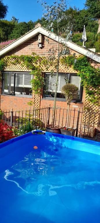 a large blue swimming pool in front of a house at The lodge in Blackwood