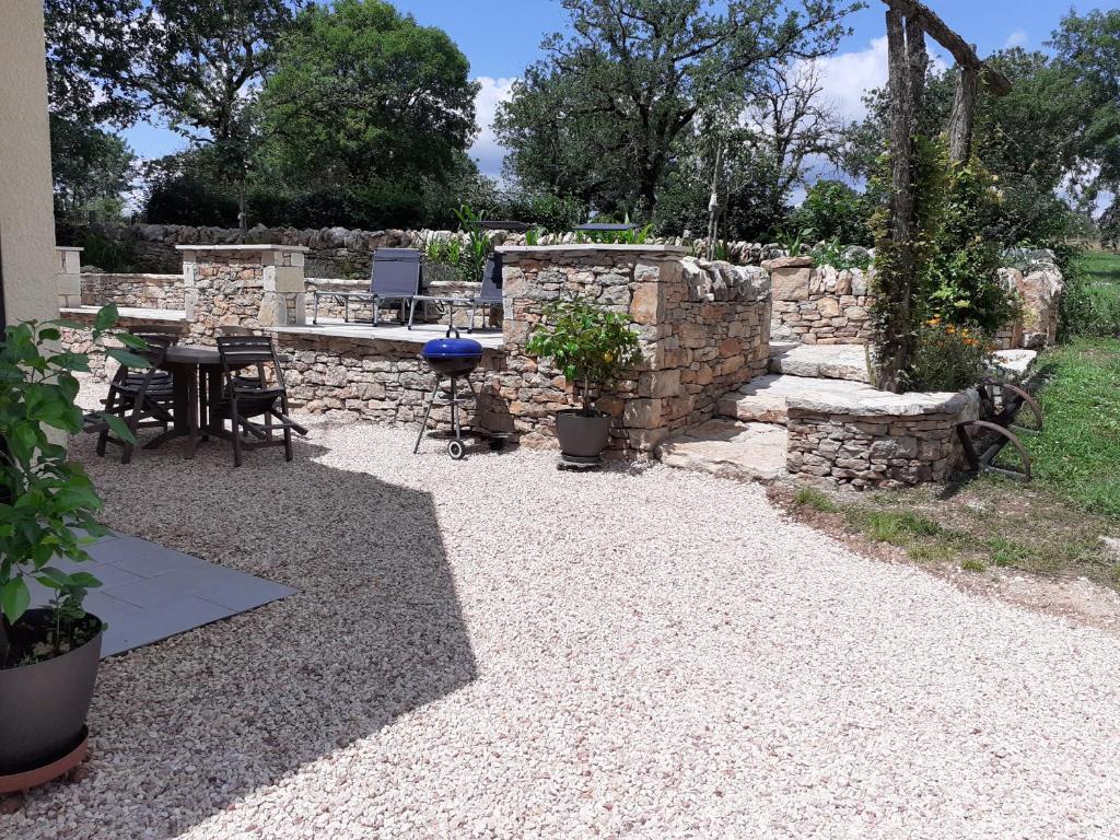 d'une terrasse avec une table et un mur en pierre. dans l'établissement Chez Celine, à Rocamadour