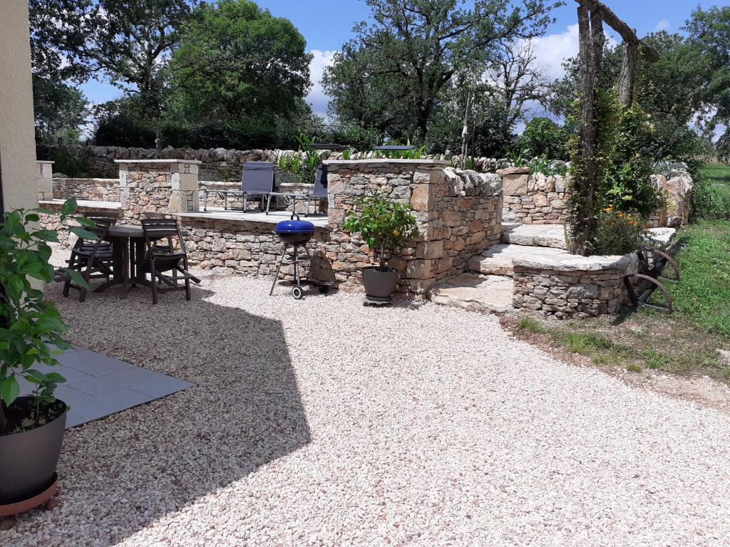 a patio with a table and a stone wall at Chez Celine in Rocamadour