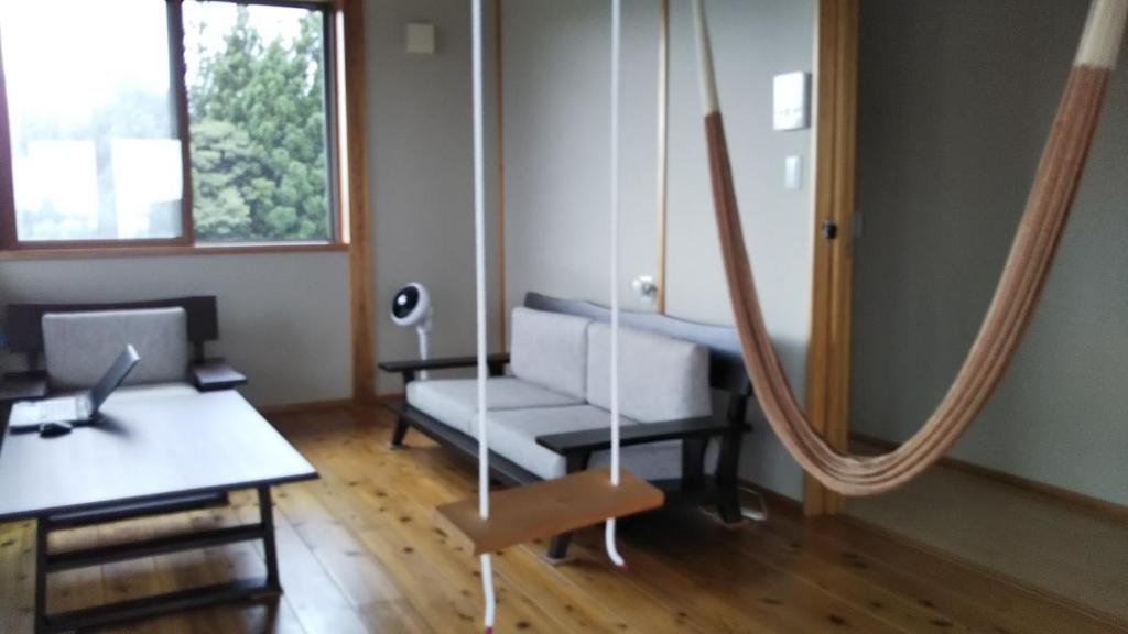 a living room with a couch and a table and a desk at Nihonkai Nou no yado Miharashitei - Vacation STAY 11631 in Itoigawa