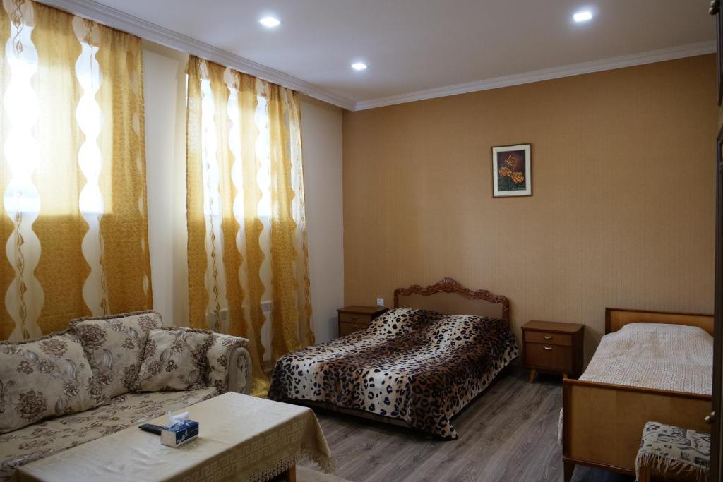 sala de estar con sofá y cama en Guest House Kumayri, en Gyumri