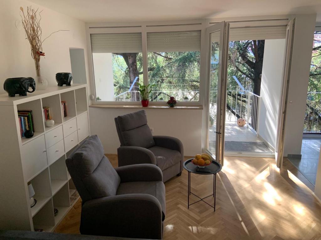 a living room with two chairs and a table at Apartment Bono Poreč in Poreč