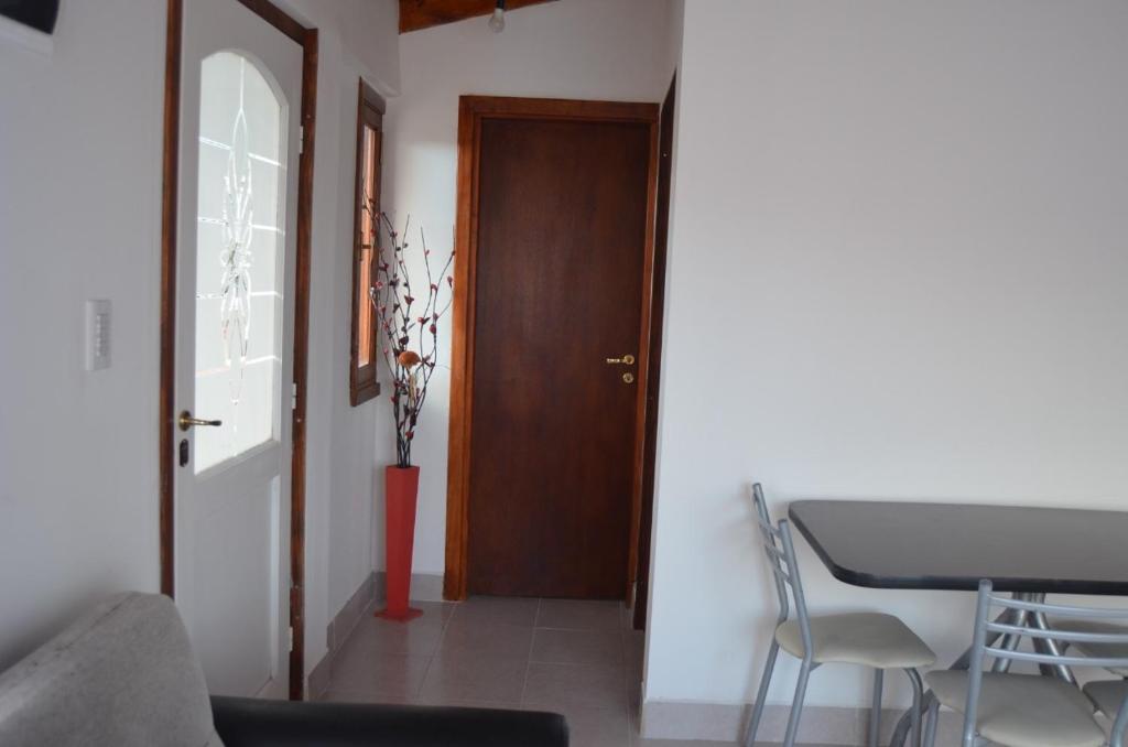 a room with a door and a table and chairs at TAID in Esquel