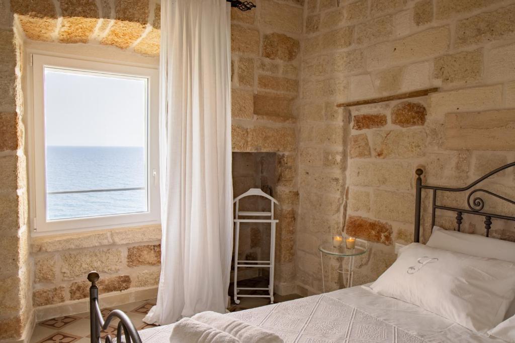 sypialnia z łóżkiem i oknem z widokiem na ocean w obiekcie Suite Polignano w mieście Polignano a Mare
