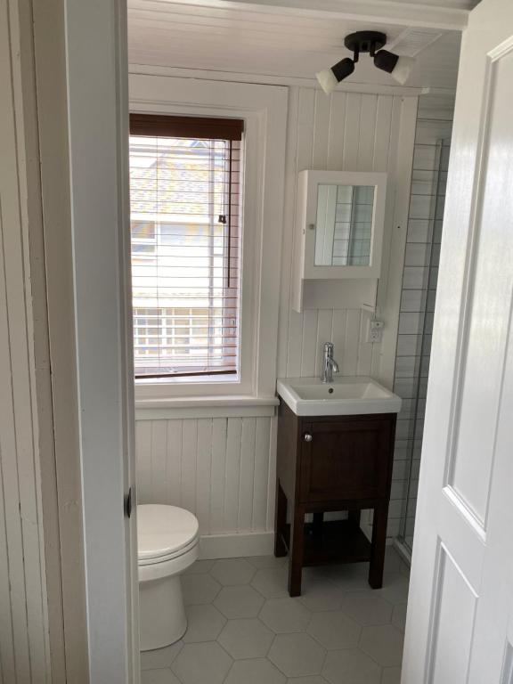 a bathroom with a toilet and a sink and a window at La Maison entre Mer Montagnes in Cap-Chat