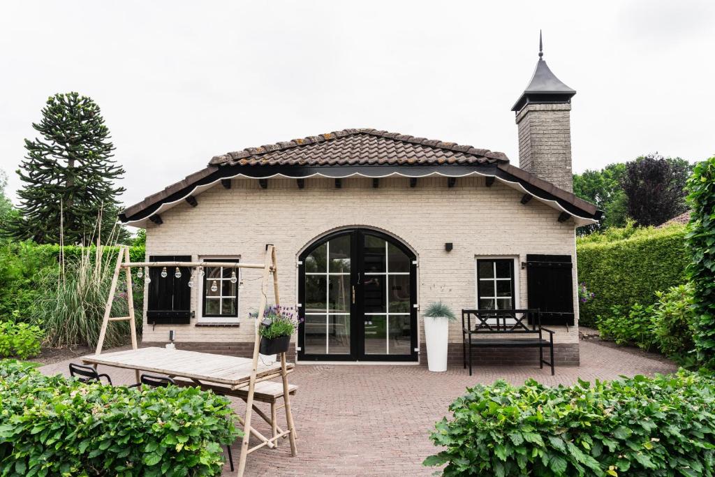 une petite maison avec une table et un banc dans l'établissement Bed en Wellness Groenrust, à Ermelo