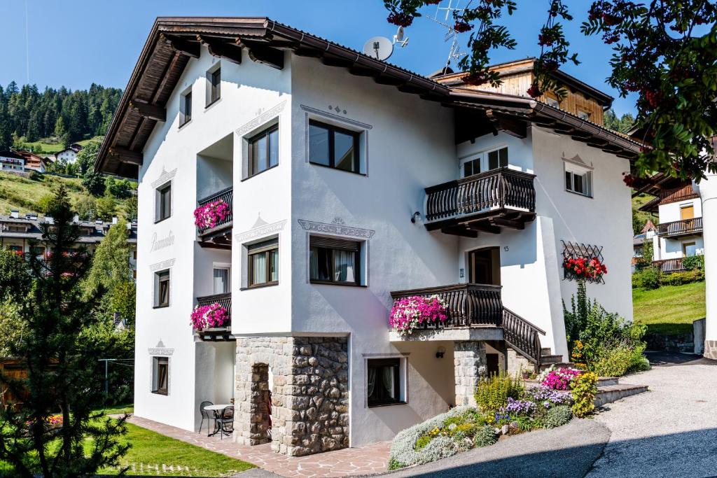 a white building with balconies and flowers at Pramulin in Selva di Val Gardena