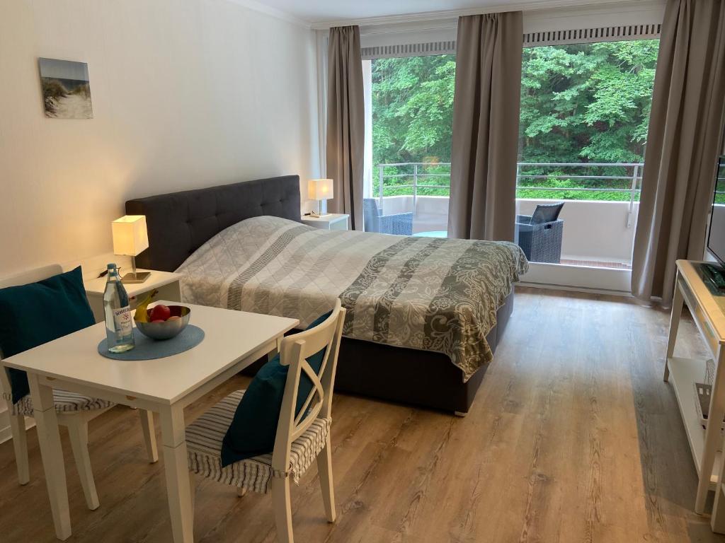 1 dormitorio con cama, mesa y comedor en Glück am Meer en Glücksburg