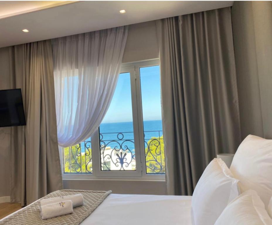1 dormitorio con cama y ventana grande en AMI MAR Hotel, en Sarandë