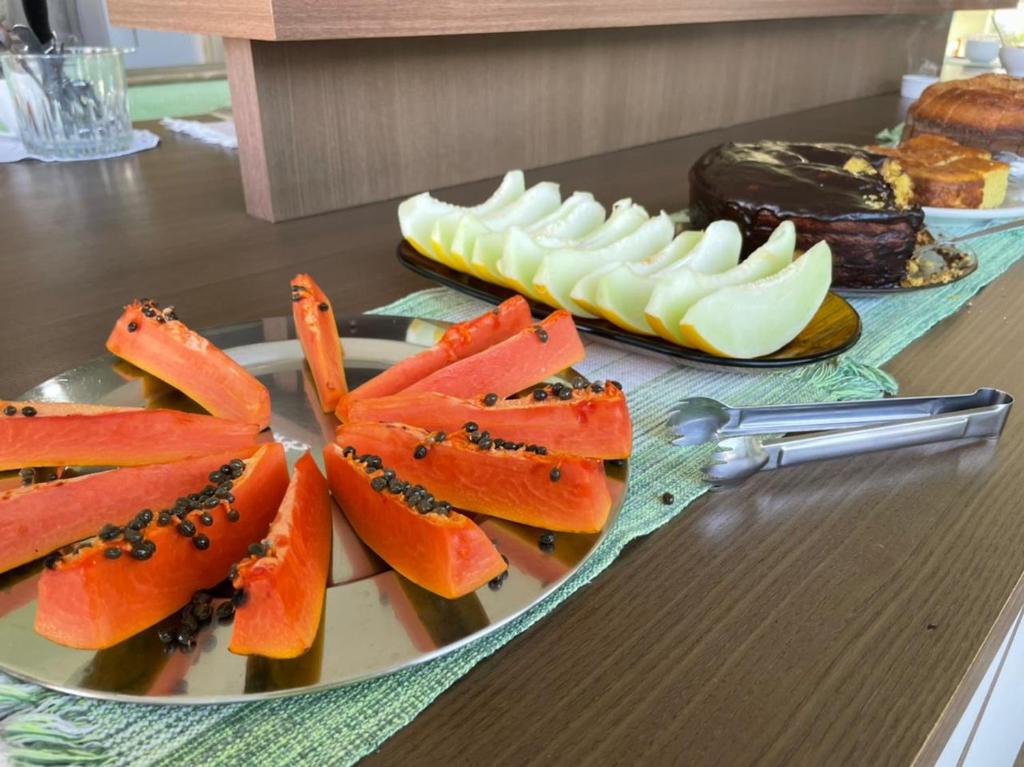 ein Teller mit Essen und Obst auf einem Tisch in der Unterkunft Pousada Aliens in São Thomé das Letras