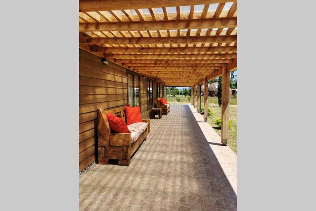 un patio al aire libre con pérgola de madera en Cunco casa de campo, en Temuco