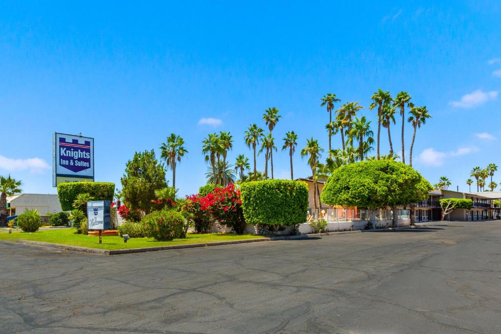 un parking avec des palmiers et un hôtel dans l'établissement Knights Inn and Suites Yuma, à Yuma