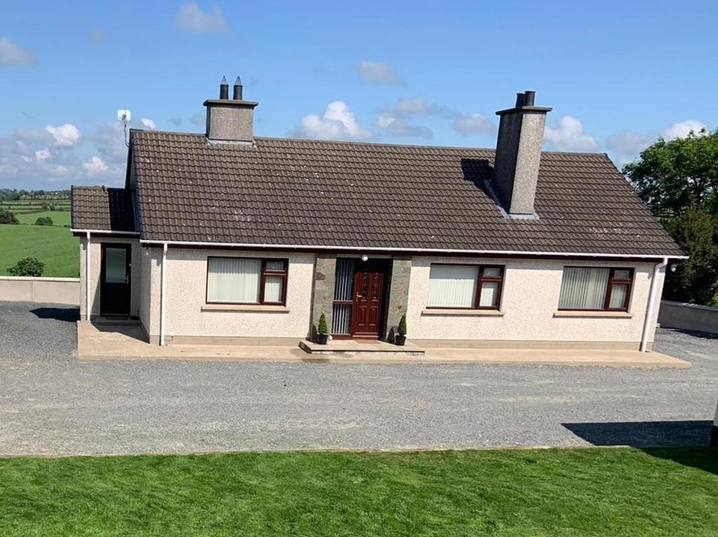 a white house with a brown roof at Gracey's Hillside Lodge in Ballyward