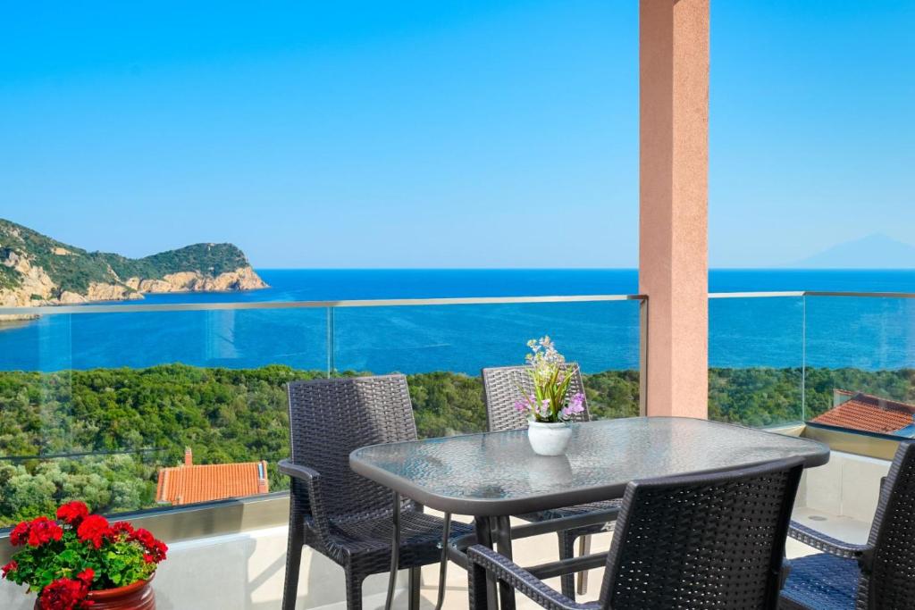 a table and chairs on a balcony with a view of the ocean at Onar in Skala Marion