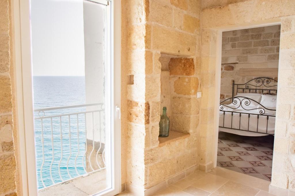 sypialnia z oknem z widokiem na ocean w obiekcie Suite Polignano w mieście Polignano a Mare