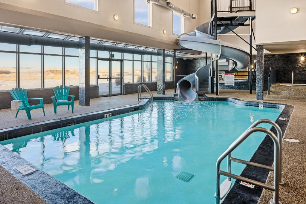 a swimming pool with a slide in a building at Home Inn & Suites - Swift Current in Swift Current