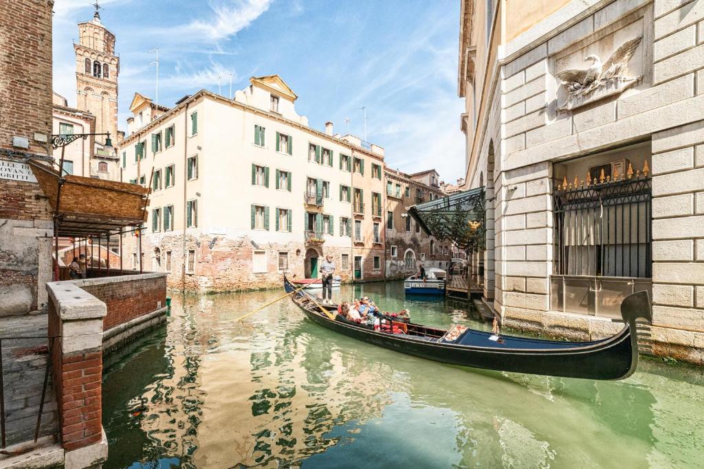 Casanova Fenice - Canal View في البندقية: مجموعة من الناس يركبون جندولا أسفل القناة