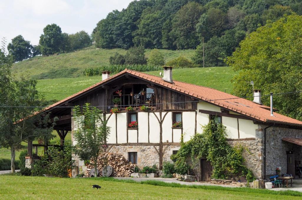 una casa en un campo con una persona en un balcón en Otardi, en Asteasu