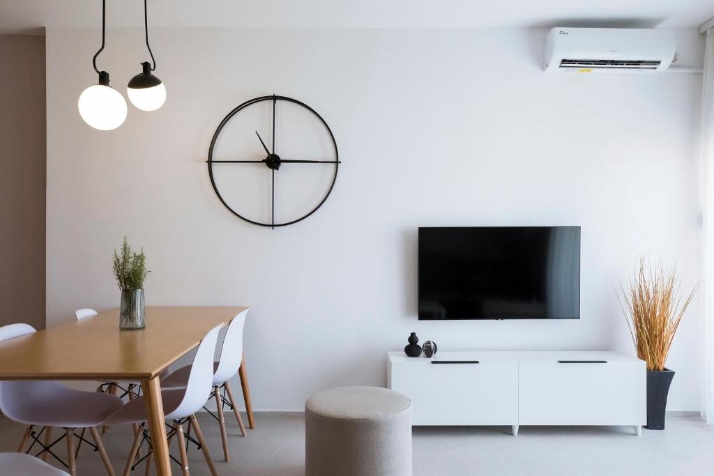 comedor con mesa y reloj en la pared en Saranda Nik Apartment, en Sarandë