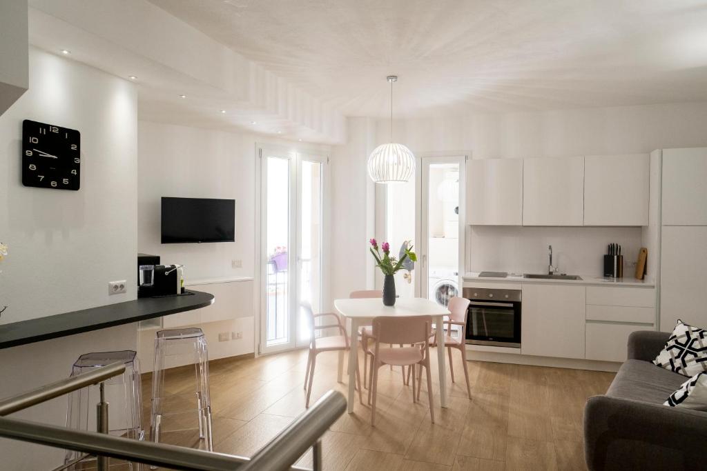een keuken en een woonkamer met een tafel en stoelen bij Dadà Loft in Cefalù