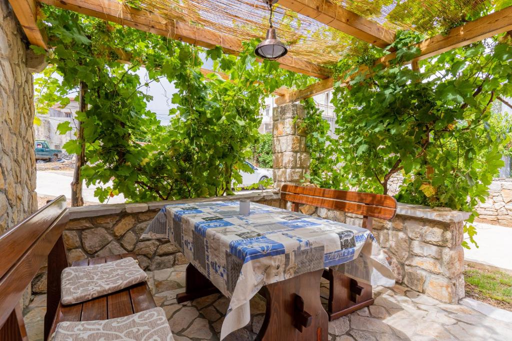 a table and chairs sitting under a wooden pergola at Apartment Jurasić in Orlec