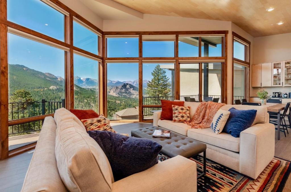 a living room with couches and a large window at Azure Vista Vacation Home at Windcliff home in Estes Park