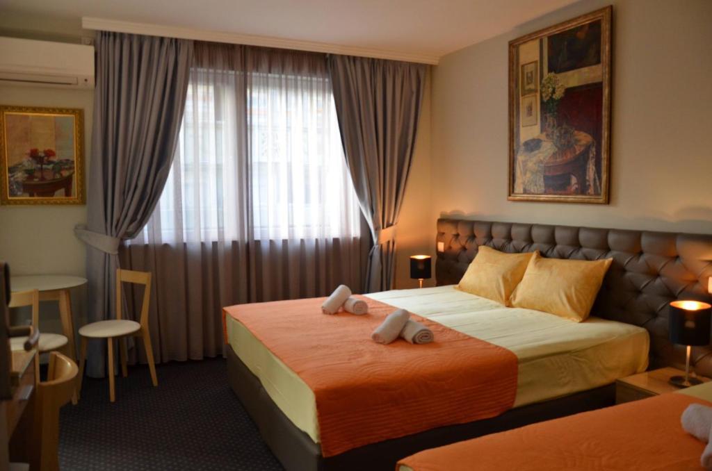 a hotel room with two beds and a window at Ars Square Apartments in Skopje