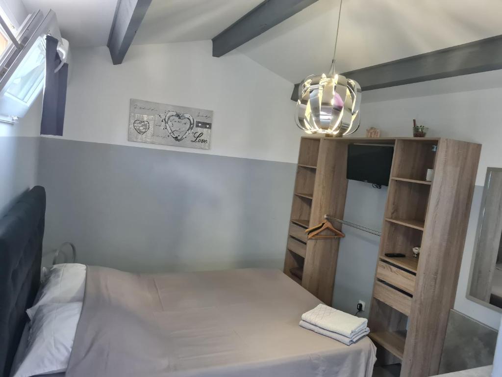 Dormitorio pequeño con cama y estante en Chambre cosy avec terrasse en Arles