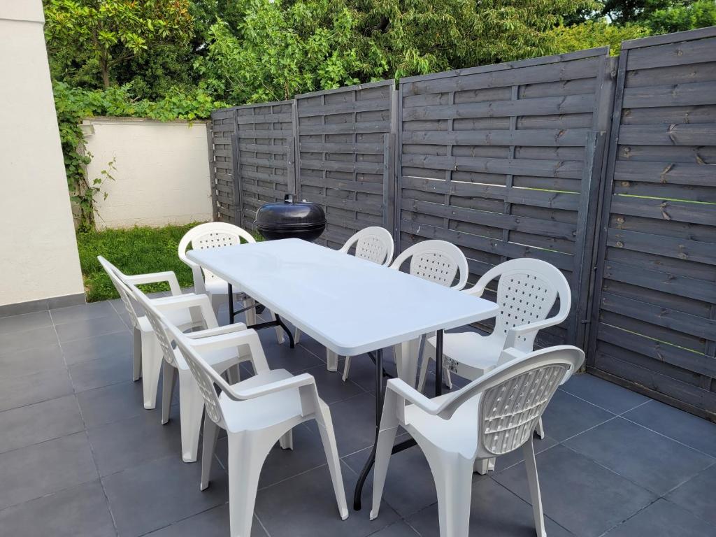 een witte tafel en stoelen op een patio bij 100m2 2 chambres 8 personnes - Grand parking et terrasse privée - Proche CDG-Parc expositions-Paris-Astérix-Disney in Villepinte