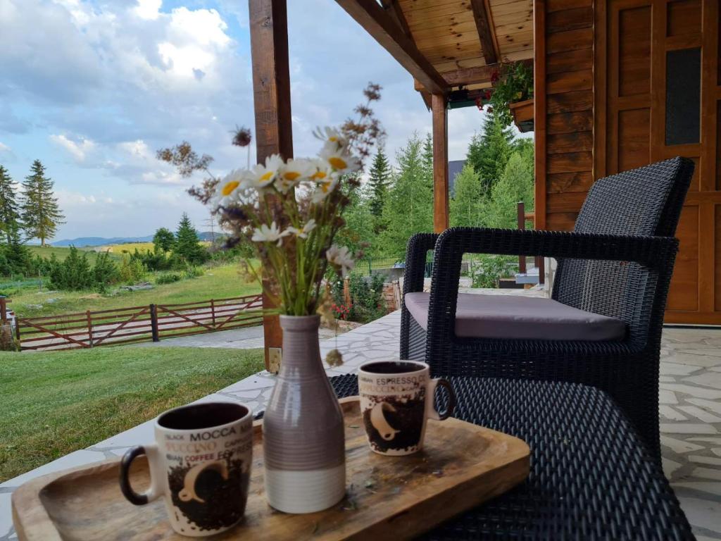 uma bandeja com duas chávenas e um vaso numa mesa em Mountain Star em Žabljak