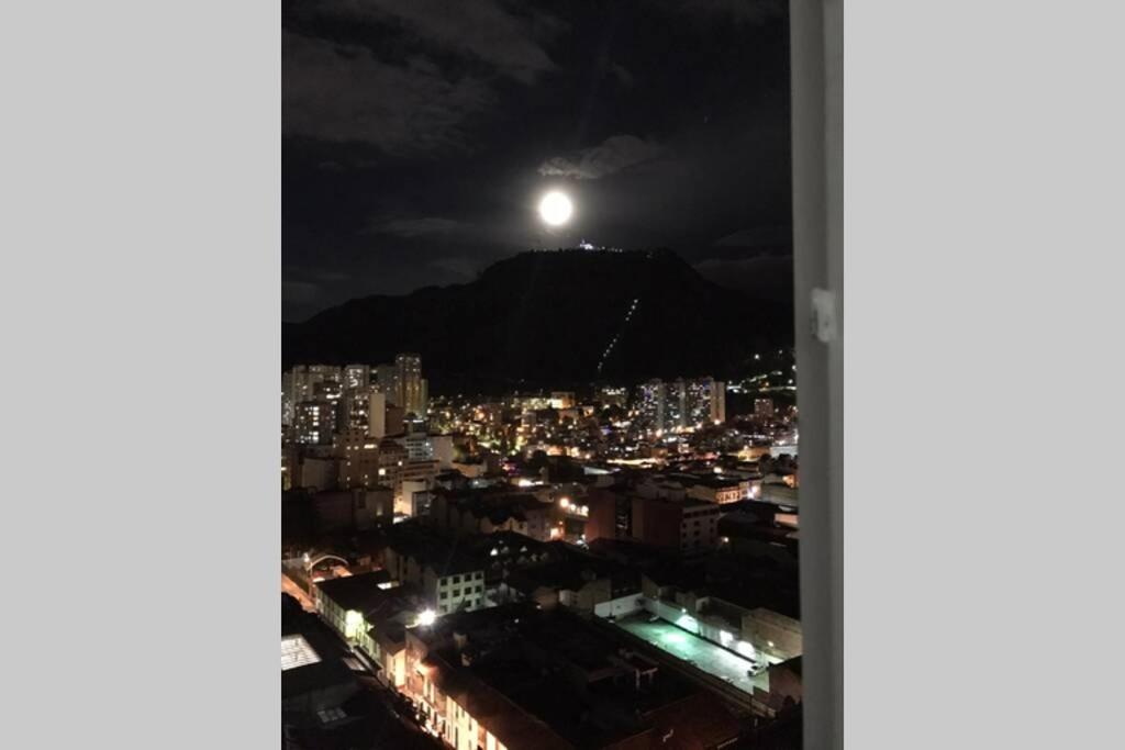 a view of a city at night with the moon at 1902 - Increíble Apto con Vista a la Ciudad in Bogotá