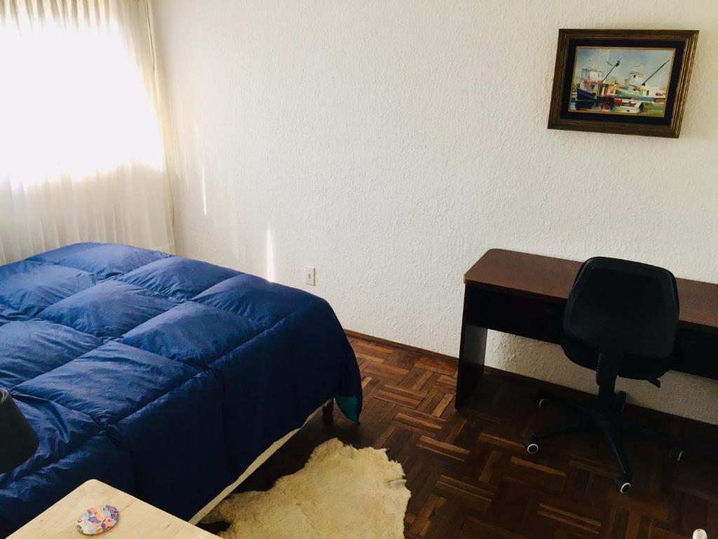 Schlafzimmer mit einem Bett, einem Schreibtisch und einem Stuhl in der Unterkunft Penthouse Duplex en Pocitos in Montevideo